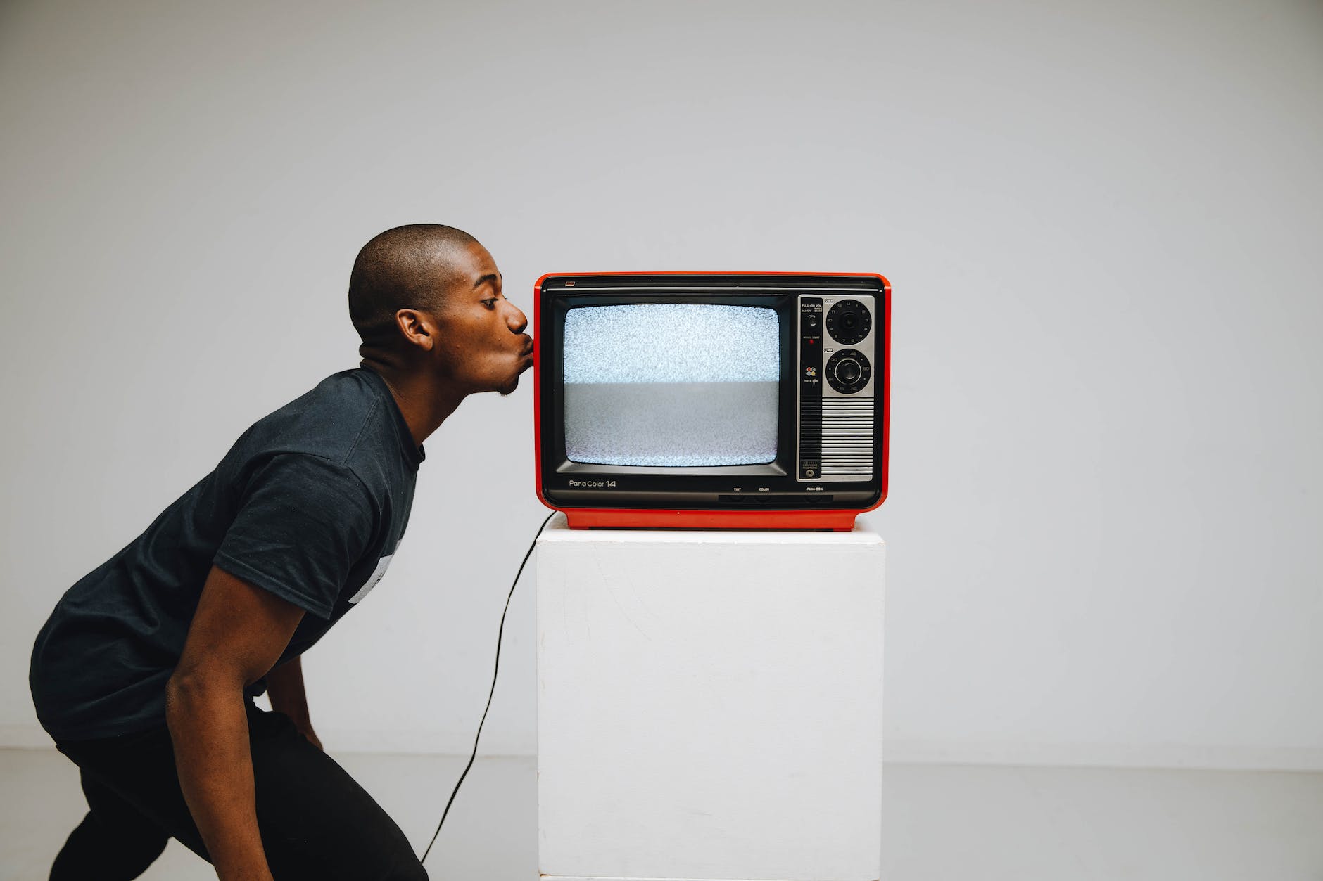 photo of a man kissing a television